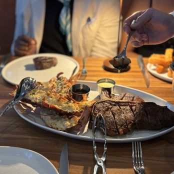 Marbled & Fin signature dishes Wood-Fired Steaks, Seafood Towers, Lobster Thermidor, House-made Parker House Rolls